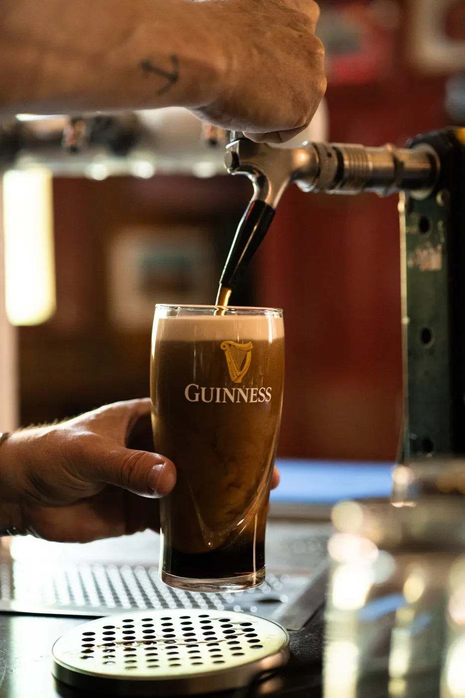 A pint of Guinness being poured at the bar